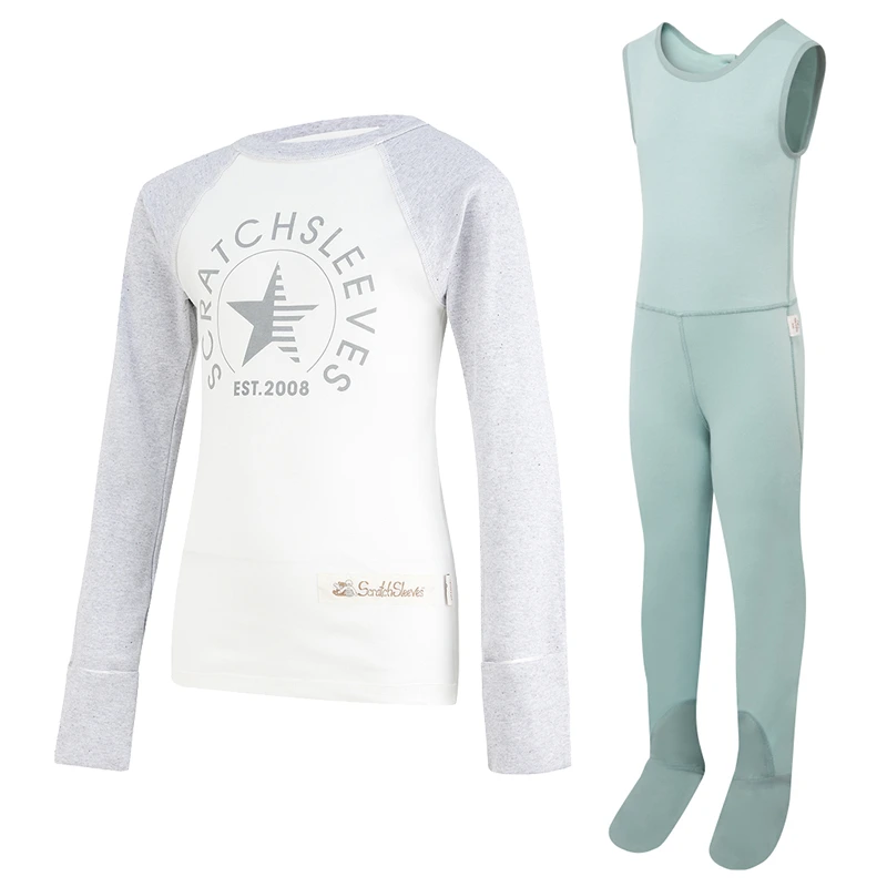 Front view of children's baseball style flip-mitt ScratchSleeves pyjama top with external shoulder, neck and hem seams. White body with grey screen printed logo featuring a bear and est.2008. Grey marl neck and sleeves, with mitts folded back. 100% cotton body and 100% natural silk mitts. External label and branding on the left side towards the base of the top. Front view of ScratchSleeves childrens seafoam dungarees with no inside leg seam and sewn in feet. Closed feet with a layer of grey, 100% woven cotton over the front of the foot and under the toe. Seafoam green, sleeveless body in 100% cotton jersey, edged in grey woven cotton trim on the arm and neck.