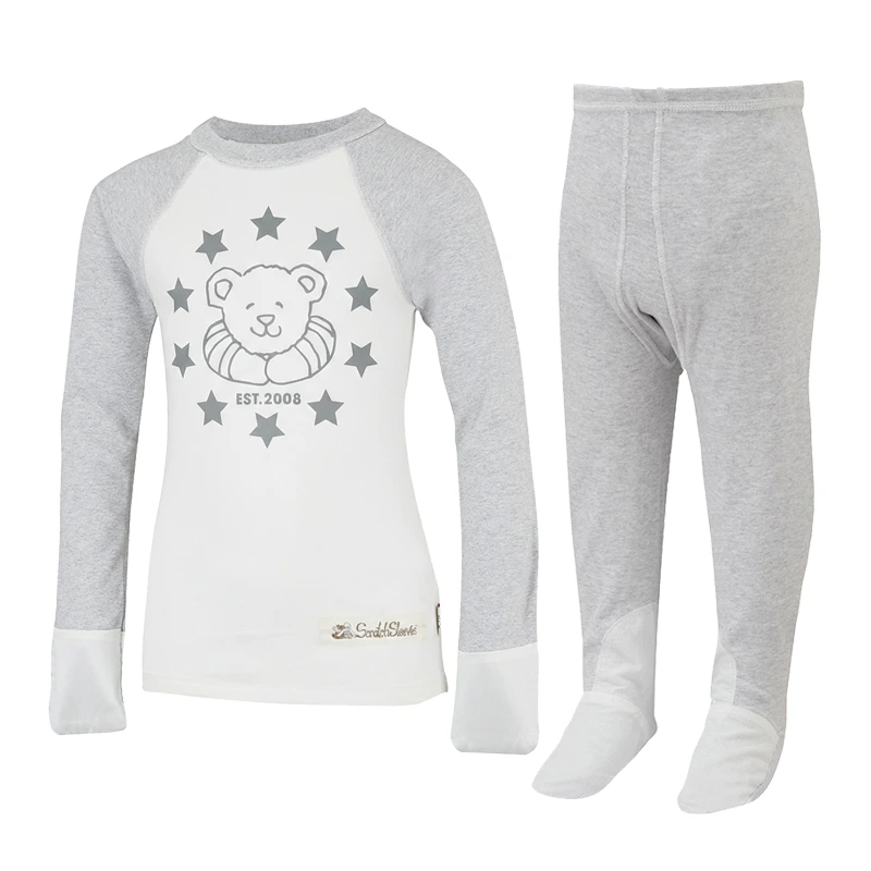 Front view of baseball style ScratchSleeves pyjama top with external shoulder, neck and hem seams. White body with grey printed logo featuring a bear, stars and est.2008. Grey marl neck and sleeves, with white sewn in mitts. 100% cotton body and 100% natural silk mitts. External label and branding on the left side towards the base of the top. Front view of ScratchSleeves grey marl pyjama bottoms with no inside leg seam and sewn in feet. Closed feet with a layer of white, 100% woven cotton over the front of the foot and under the toe. 100% cotton jersey.