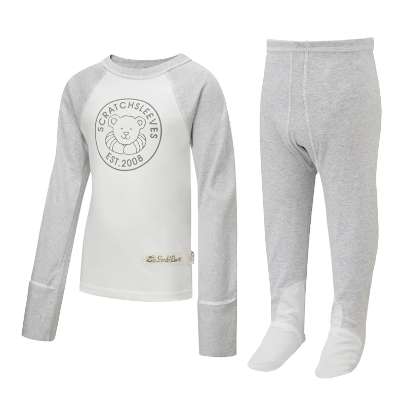 Front view of children's baseball style flip-mitt ScratchSleeves pyjama top with external shoulder, neck and hem seams. White body with grey screen printed logo featuring a bear and est.2008. Grey marl neck and sleeves, with mitts folded back. 100% cotton body and 100% natural silk mitts. External label and branding on the left side towards the base of the top. Front view of ScratchSleeves childrens seafoam dungarees with no inside leg seam and sewn in feet. Closed feet with a layer of grey, 100% woven cotton over the front of the foot and under the toe. Seafoam green, sleeveless body in 100% cotton jersey, edged in grey woven cotton trim on the arm and neck.
